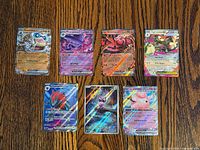 Fronts of seven Pokémon EX and IR cards on wooden surface
