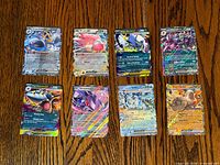 Fronts of all eight Pokémon EX cards arranged in two rows on wood surface