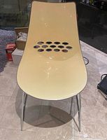 Front view of Calligaris Jam chair showing cream seat, oval cut-outs, chrome legs