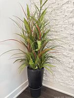 Full view of artificial plant and black planter