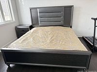King bed frame with padded headboard visible