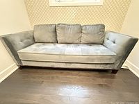 Front view of gray three-seat sofa showing cushions, arms and upholstery