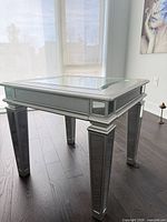 Square mirrored side table with glass inset top, showing full piece