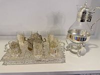 Group shot showing tray, six cups, sugar bowl, carafe and stand