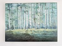 Front view of framed landscape painting showing birch forest scene and artist signature