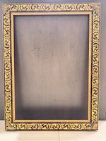 Full view of ornate gold and black wood picture frame, front side