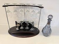 Rack holding six hanging glasses, three standing glasses, corkscrew, decanter beside