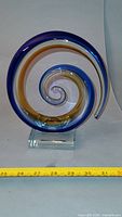 Full view of blue and yellow glass spiral on base