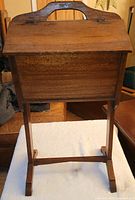 Front view of wooden standing sewing box on pedestal stand