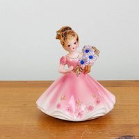 Front view of Josef Originals September figurine on wooden surface