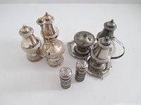 All cruet pieces grouped: two complete cruet sets and separate salt & pepper shakers