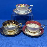 Three Paragon cup and saucer sets displayed side by side