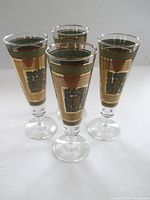 Four avocado green and gold footed pilsner glasses, angled view