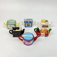 Front view showing all six miniature teapots