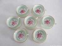 Top view of seven matching Paragon tea cup and saucer sets arranged in a circle