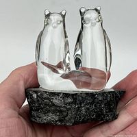 Front view of crystal double polar bear sculpture on dark stone base in hand