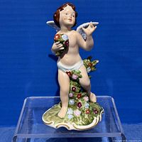Front view of porcelain cherub figurine on clear stand