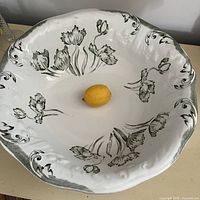 Top view of large tulip-decorated basin with lemon for scale