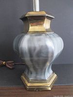 Lamp base showing mixed metal body and brass base