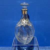 Front view of clear glass decanter with silver overlay and stopper
