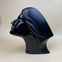 Left profile of black ceramic bust showing glossy finish