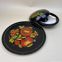 Plate and opened covered dish showing floral painting and note inside
