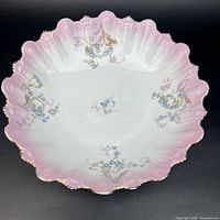 Top view showing full design, pink rim, floral decoration, scalloped gilt edge
