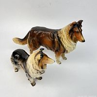 Both collie figurines side by side showing size difference and overall condition