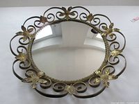 Front view of round convex mirror showing complete ornate brass frame