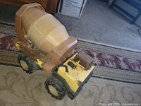 Side view of yellow Tonka cement mixer showing cab, drum and wheels