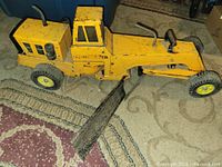 Left side view of yellow Tonka road grader showing articulation and wheels