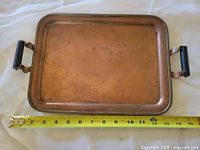 Top view of copper tray with measuring tape showing dimensions