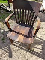 front view of wooden slat-back armchair showing seat and arms