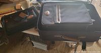Open large suitcase with medium suitcase inside and small tote beside