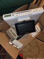 Top view of Electrohome TV/DVD unit with flip-down screen, bracket, power cord and accessories in box