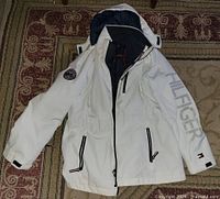 White outer shell with hood and branding visible