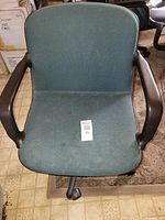 Front view of Comforto swivel chair showing green fabric seat, armrests, seat label visible