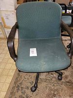 Front view of teal upholstered office chair with arms and casters