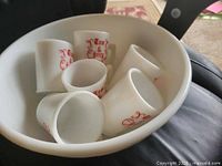 Top view of bowl containing six mugs