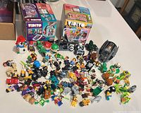 Overview of lot showing two sealed Vidiyo boxes, large spread of loose minifigure parts and small builds