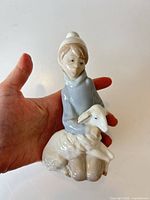 Front view of Lladro porcelain figurine in hand for scale