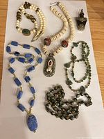 All five necklaces and snuff bottle laid out