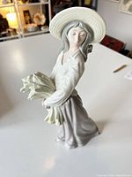 Front angled view of NAO figurine showing woman with wheat bundle