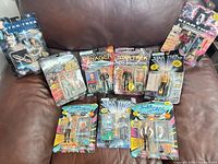 Group shot of 9 sealed Playmates Star Trek figures on brown leather surface
