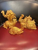 Group of three gold camel figurines on chair
