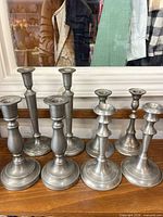 All eight pewter candlesticks lined up