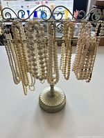 Front view of necklaces hanging on metal stand