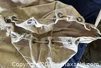 Top opening showing metal grommets and rope drawstring on canvas bag