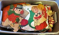 Overview of tote showing die-cut snowman and caroler decorations atop assorted contents