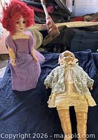 Front view of both dolls on dark cloth background